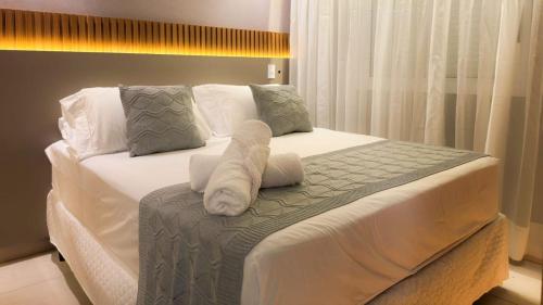 a bedroom with a bed with towels on it at Apartamento com aconchego e modernidade Apogeo in Ribeirão Preto