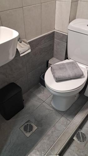 a bathroom with a white toilet and a sink at Meerithic ROKKA ROOMS in Vourvourou