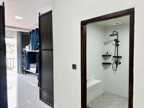 ルアンパバーンにあるMekong Theme Hostel,Affiliated by Huayeのウォークインシャワーと鏡付きのバスルーム