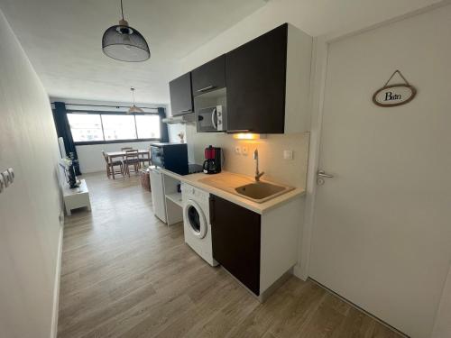 a kitchen with a sink and a washing machine at Port de Rochefort in Rochefort