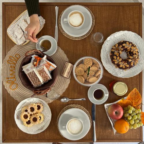 een houten tafel met daarop borden en kommen met eten bij Corte 'e Susu - Domo Experience in Ortueri