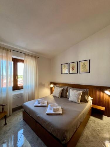 a bedroom with a large bed with two towels on it at Corte 'e Susu - Domo Experience in Ortueri