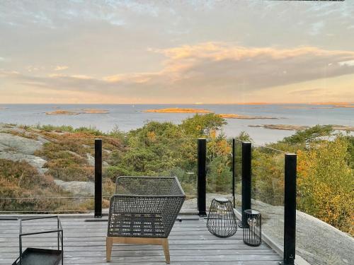 a table and chairs on a deck with a view of the water at Fantastisk Hytte Med Udsigt Over Ytre Oslofjord in Gressvik