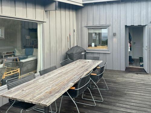 a wooden table and chairs on a patio at Fantastisk Hytte Med Udsigt Over Ytre Oslofjord in Gressvik