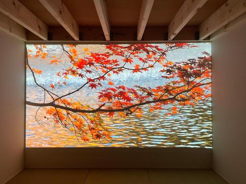 a painting of a tree over a body of water at Le Cave Troll ル カーブ トロル in Mitaka
