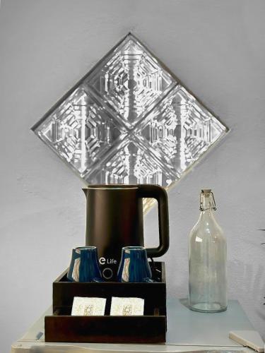 a table with a tea kettle and a bottle at Friends Retreat - Phuket Airport in Ban Bo Han