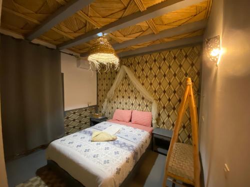 a bedroom with a bed with pink pillows at Etoile d Or Ksar Ait Ben Haddou in Aït Ben Haddou