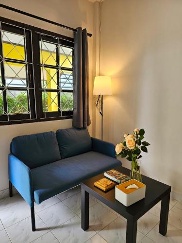 a living room with a blue couch and a table at Friends Retreat - Phuket Airport in Ban Bo Han