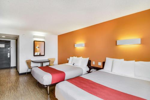 a hotel room with two beds and a table at Motel 6-Carson, CA in Carson