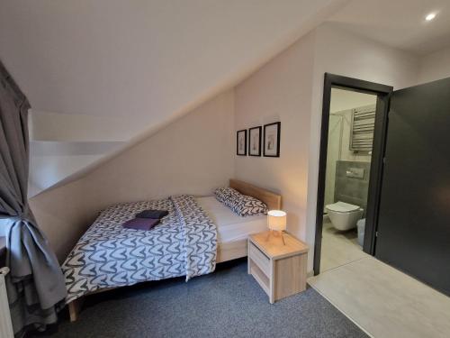 a small bedroom with a bed and a bathroom at Willa Lawenda- Pokój Superior 7 in Rytro