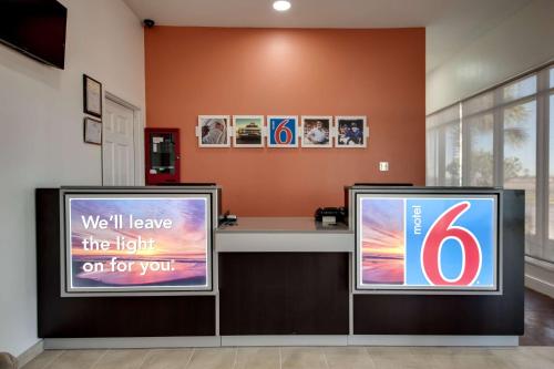 two television screens in a room with a counter at Motel 6-Jennings, LA in Jennings