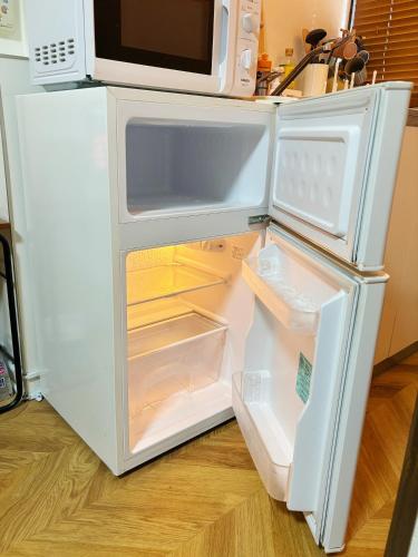 an open refrigerator with its door open in a kitchen at 芋ノ宿ー大正 in Osaka