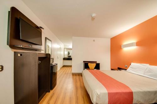 a hotel room with a bed and a flat screen tv at Motel 6-Jennings, LA in Jennings