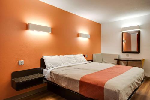 a bedroom with a large bed with orange walls at Motel 6-Jennings, LA in Jennings