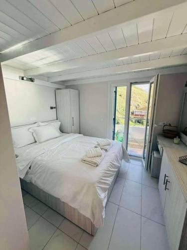 a white bedroom with a large bed in a room at Aegean View Apartment in Skala Eresou