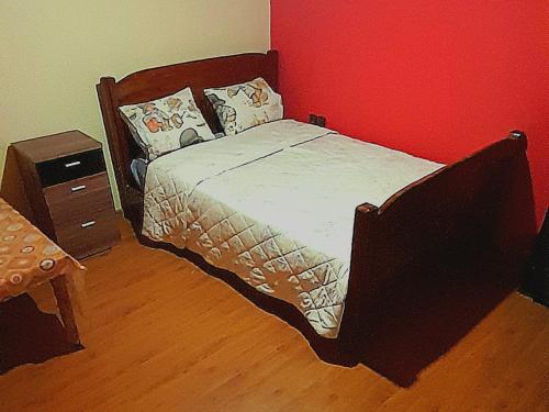 a bed in a bedroom with a red wall at Avec piscine 06-17-61-38-73 in Ifrane