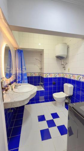 a blue and white bathroom with a toilet and a sink at Golden mile - Downtown Cairo in Cairo