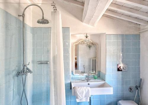a blue tiled bathroom with a sink and a shower at Chiantivillas Poggio a Vento in Badia A Passignano