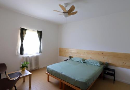 Un dormitorio con una cama y un ventilador de techo. en Komorebi, en Locatello