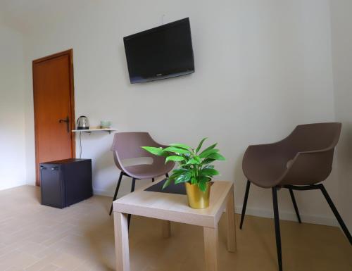 una sala de estar con 2 sillas y una planta sobre una mesa en Komorebi, en Locatello