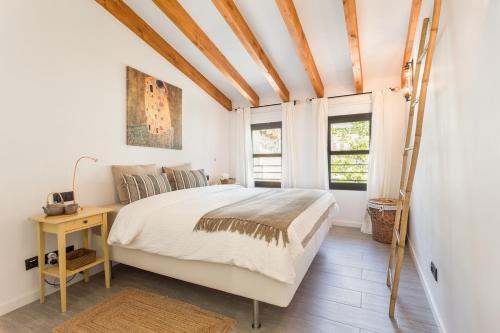 um quarto com uma cama, uma escrivaninha e janelas em Ca Na Búger em Valldemossa