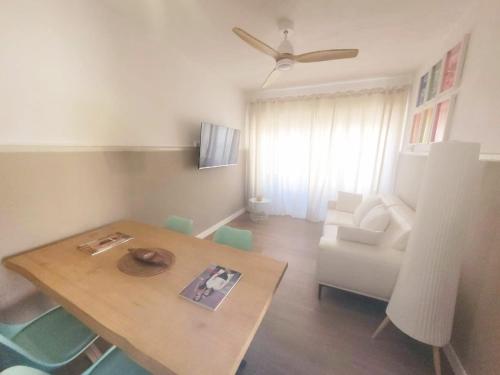 un soggiorno con tavolo e sedia bianca di Candela con amor a Punta Umbría