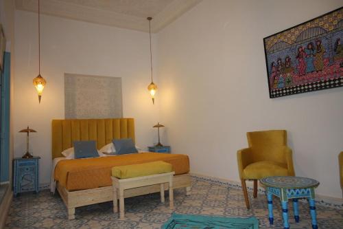 ein Schlafzimmer mit einem Bett und einem Stuhl in der Unterkunft Palais el Abbassia in Marrakesch