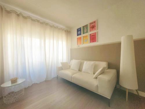 un soggiorno con un divano bianco e un tavolo di Candela con amor a Punta Umbría