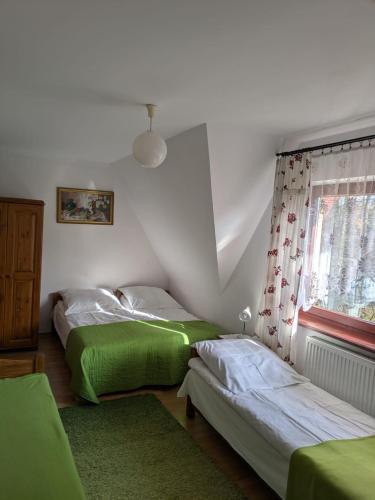 a bedroom with two beds and a window at Dom Wypoczynkowy U Kasi in Jurgów