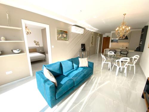 a living room with a blue couch and a table at MIA Black Luxury Suite - luxury topfloor stay with private terrace in Qawra - ADULTS ONLY - 1 masterbed 2 bathroom in St. Paul's Bay