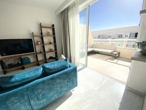 a living room with a blue couch and a television at MIA Black Luxury Suite - luxury topfloor stay with private terrace in Qawra - ADULTS ONLY - 1 masterbed 2 bathroom in St. Paul's Bay