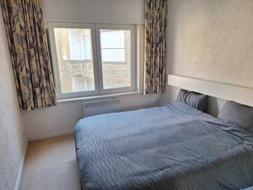 a bedroom with a bed in front of a window at Appartemment familial à Westende in Westende-Bad