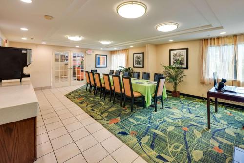 a dining room with a table and chairs on a rug at Motel 6-Milford, CT in Milford