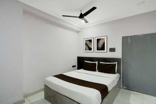 a white bedroom with a bed and a ceiling fan at Collection O Karmanghat Bus Terminal Hyderabad Formerly Hotel Chirag Stays in Hyderabad