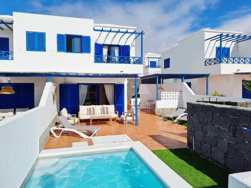 a villa with a swimming pool in front of a house at Villa Catamaran Rubicon piscina privada cerca del mar in Playa Blanca