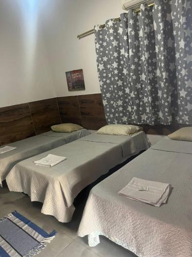 deux lits côte à côte dans une pièce dans l'établissement Hotel Colonial Lençois, à Lençóis Paulista