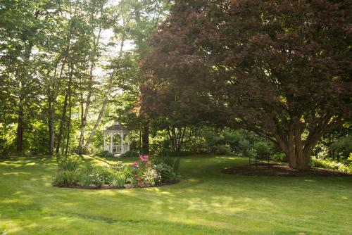 a house in the middle of a yard with green grass at Inn on Putney Road in Brattleboro