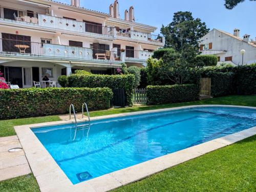 a swimming pool in front of a building at Apartamento Playa in S'Agaro