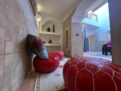 Ein Zimmer mit zwei roten Ottomanen und einer Vase in der Unterkunft Your Soul's Retreat-Entire Riad in Marrakesch