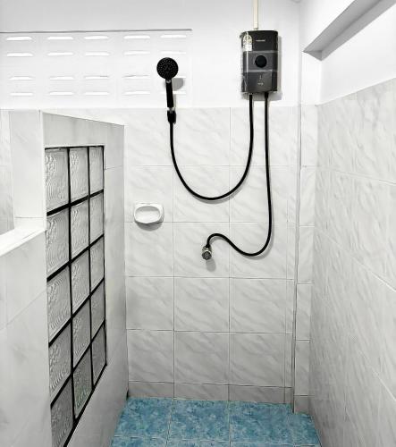 a bathroom with a shower with a camera on the wall at Friends Retreat - Phuket Airport in Ban Bo Han