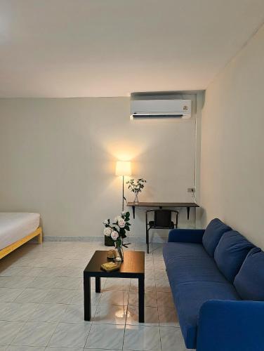 a living room with a blue couch and a table at Friends Retreat - Phuket Airport in Ban Bo Han