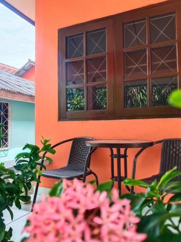 a table and chairs on a porch with pink flowers at Friends Retreat - Phuket Airport in Ban Bo Han