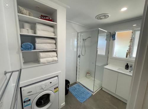 a bathroom with a washing machine and a shower at Beach House Getaway 1 in Smiths Beach