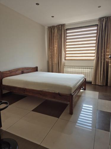 a bedroom with a bed in a room with a window at Апартамент Top Central in Yambol