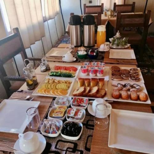een tafel met dienbladen van verschillende soorten levensmiddelen bij Sahara Luxe Camp in Merzouga