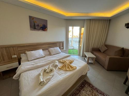 ein Schlafzimmer mit einem großen Bett und einer Couch in der Unterkunft Scandic Rezort in Hurghada