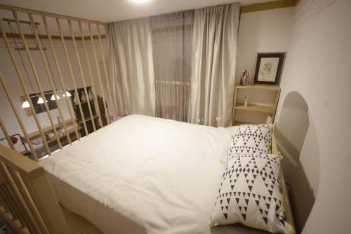Un dormitorio con una cama blanca grande y una ventana en Burbone Apartment, en Turnhout