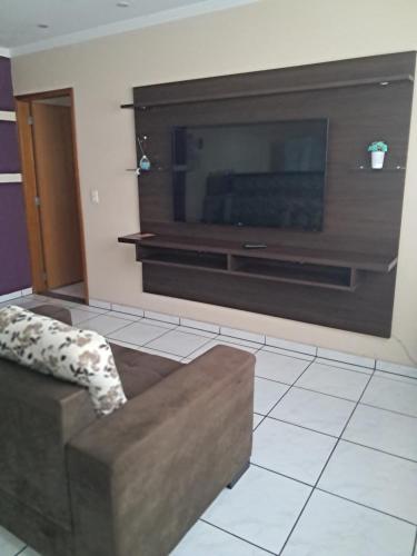 a living room with a large flat screen tv at Casa completa a 10 min do aeroporto Guarulhos in Guarulhos