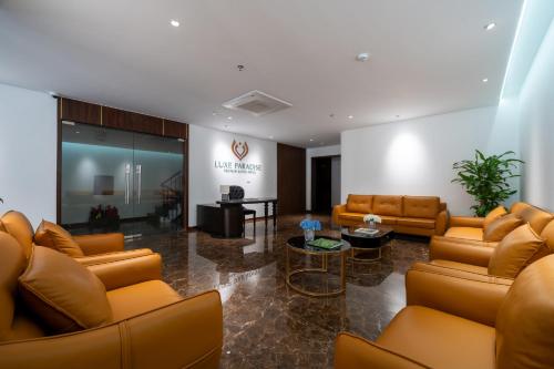 um átrio com sofás de couro castanho e uma mesa em Luxe Paradise Premium Hotel Nguyen Khac Hieu em Hanói