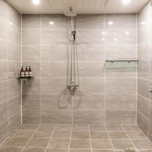a shower with a glass door in a bathroom at 와이케이호텔 in Suwon